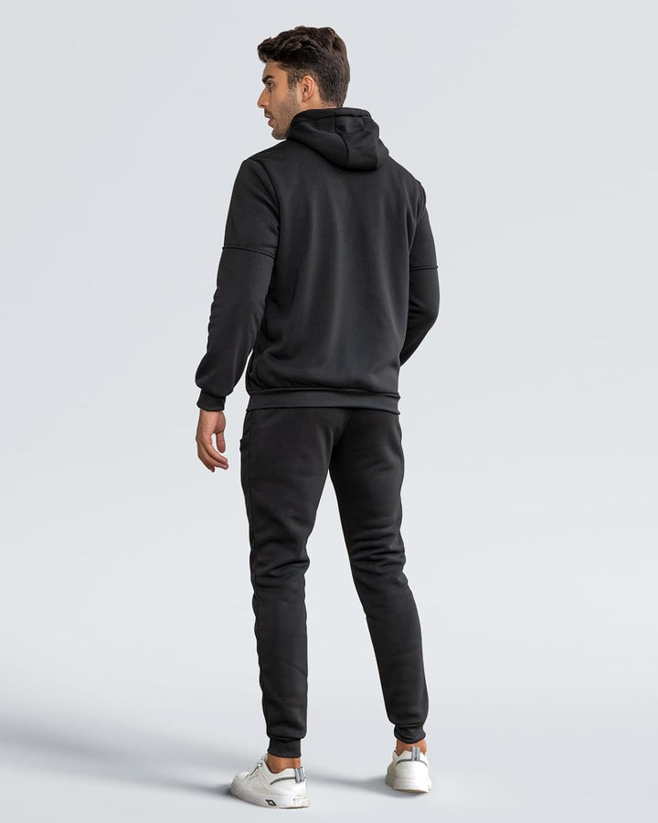 Back view of a model wearing the black hooded tracksuit with slim joggers and white trainers 22