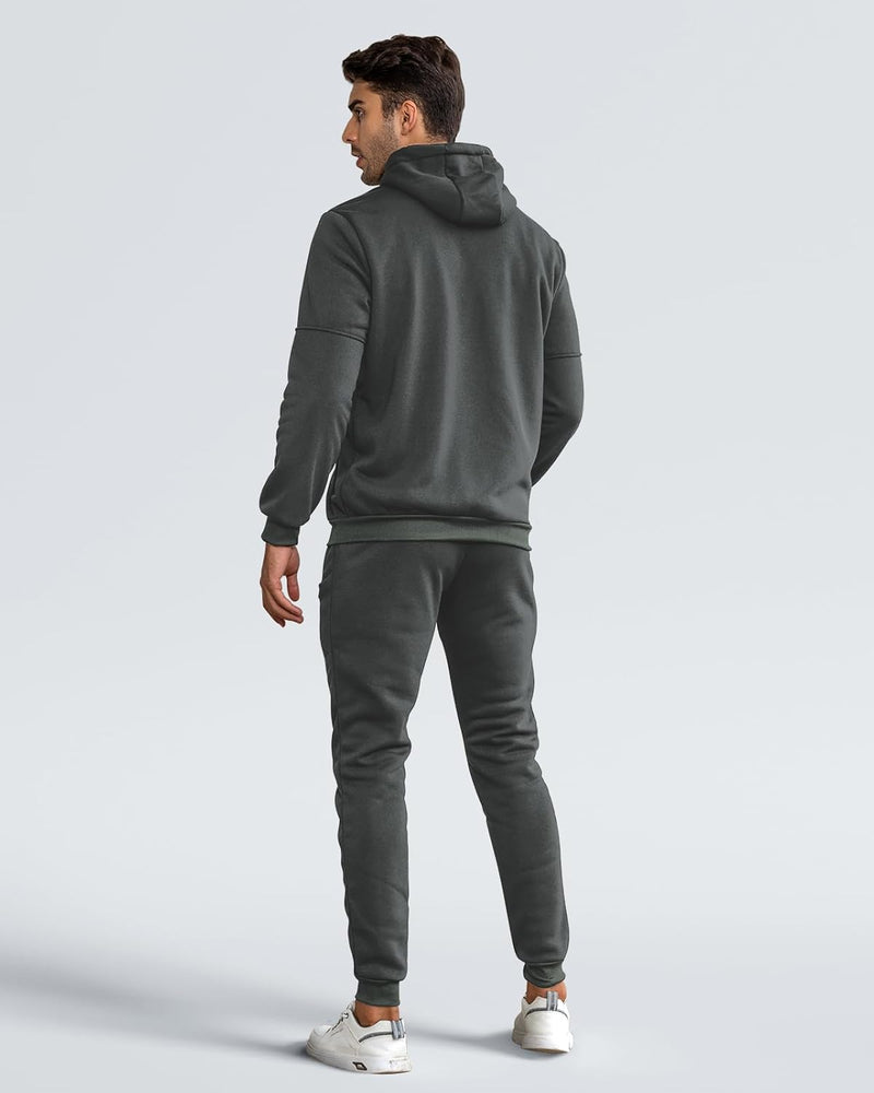 Back view of a model in the dark grey hoodie and joggers, looking over his shoulder 9