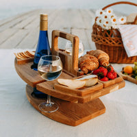 Wooden table on a picnic blanket with wine, croissants, strawberries and pear, beside a wicker basket of daisies 8