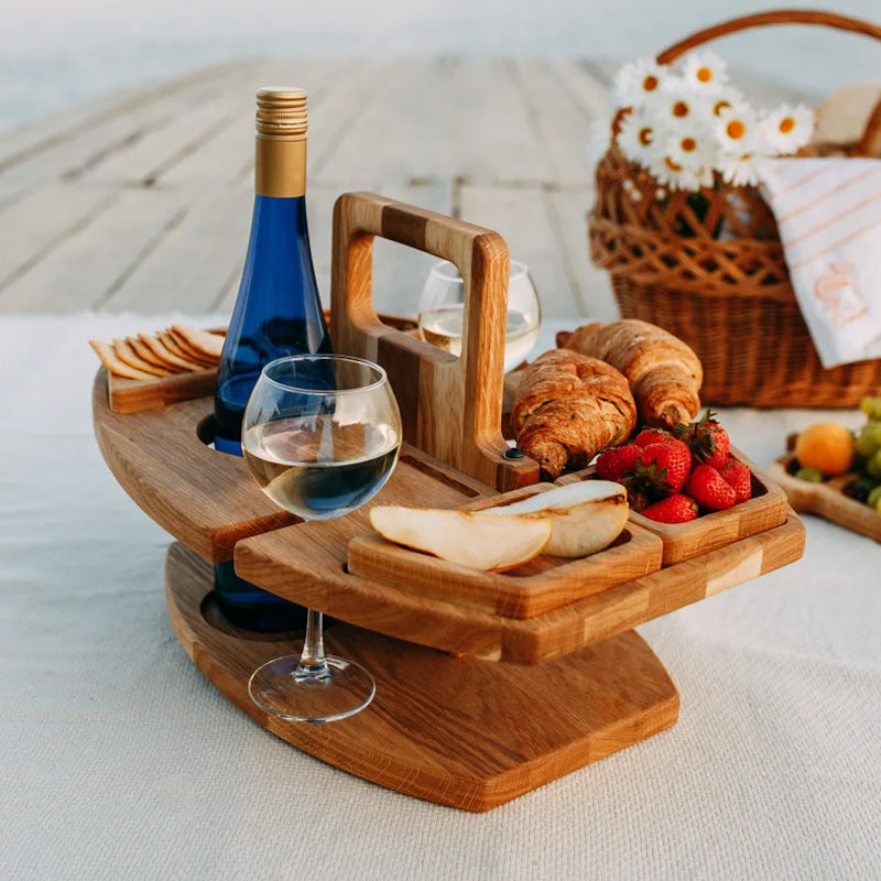 Wooden table on a picnic blanket with wine, croissants, strawberries and pear, beside a wicker basket of daisies 8