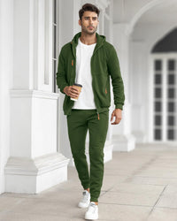 Model walking along a white colonnade in the green set, open jacket over a white t-shirt, holding a coffee 18