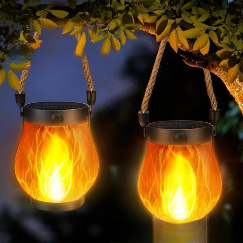 Two glowing lanterns hanging by their rope handles from a tree branch at night 8