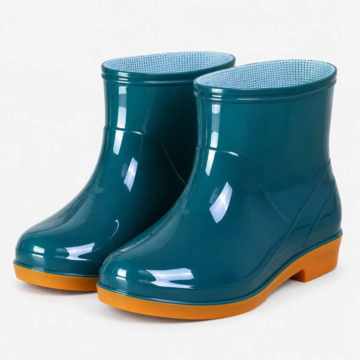 Pair of glossy teal ankle rain boots with orange soles at a three-quarter angle, showing the blue mesh lining. 2