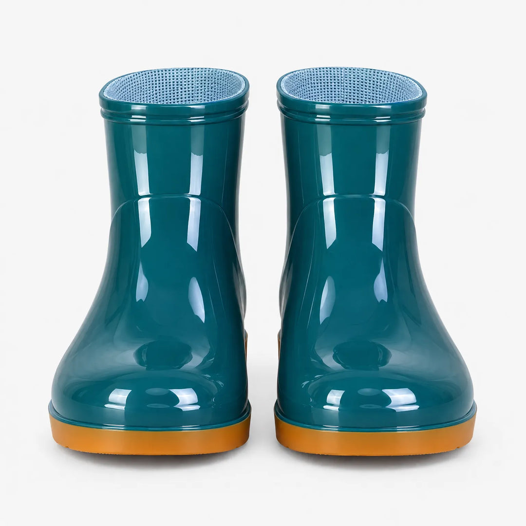 Front view of a pair of teal glossy ankle boots with orange soles and blue mesh lining. 7