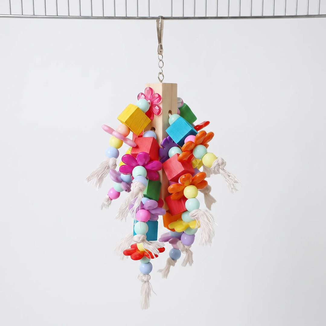 Toy hanging from a curved metal bar, showing the clip, wooden centre post, flower-shaped beads and cotton rope tassels from another angle. 4