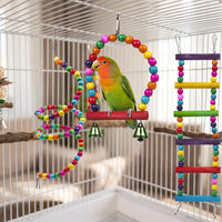 Lovebird on the beaded arch swing in a cage, beside a beaded spiral and a rainbow-rung ladder. 3