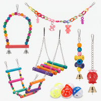 Flat lay of the full set: beaded swing, chain with charms, ladders, hanging bell toys and plastic bell balls on white. 1