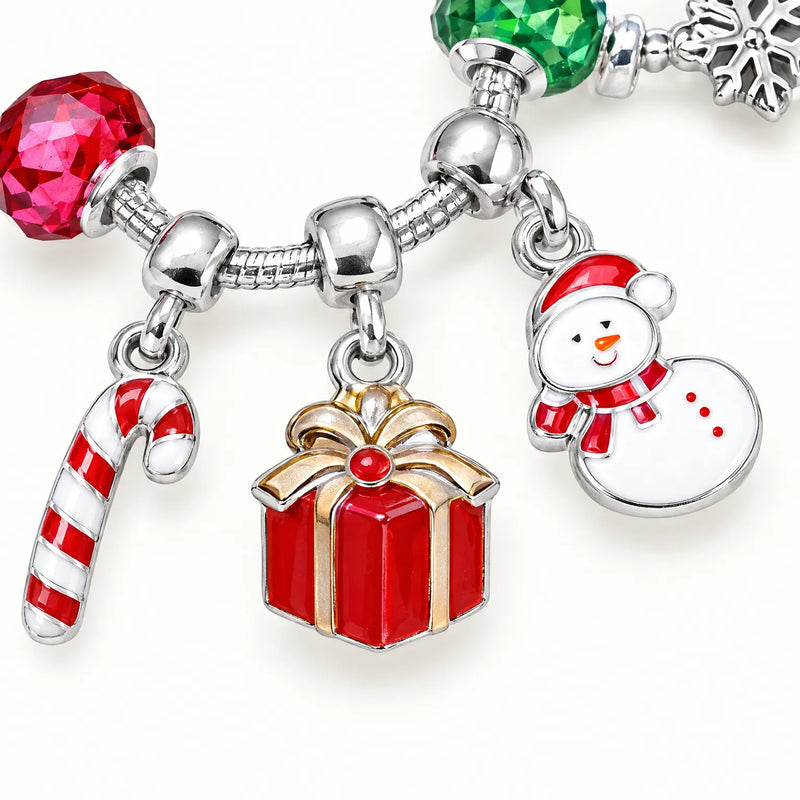 Close-up of a silver-tone bracelet with enamel candy cane, gift box and snowman charms, flanked by red and green faceted beads. 3
