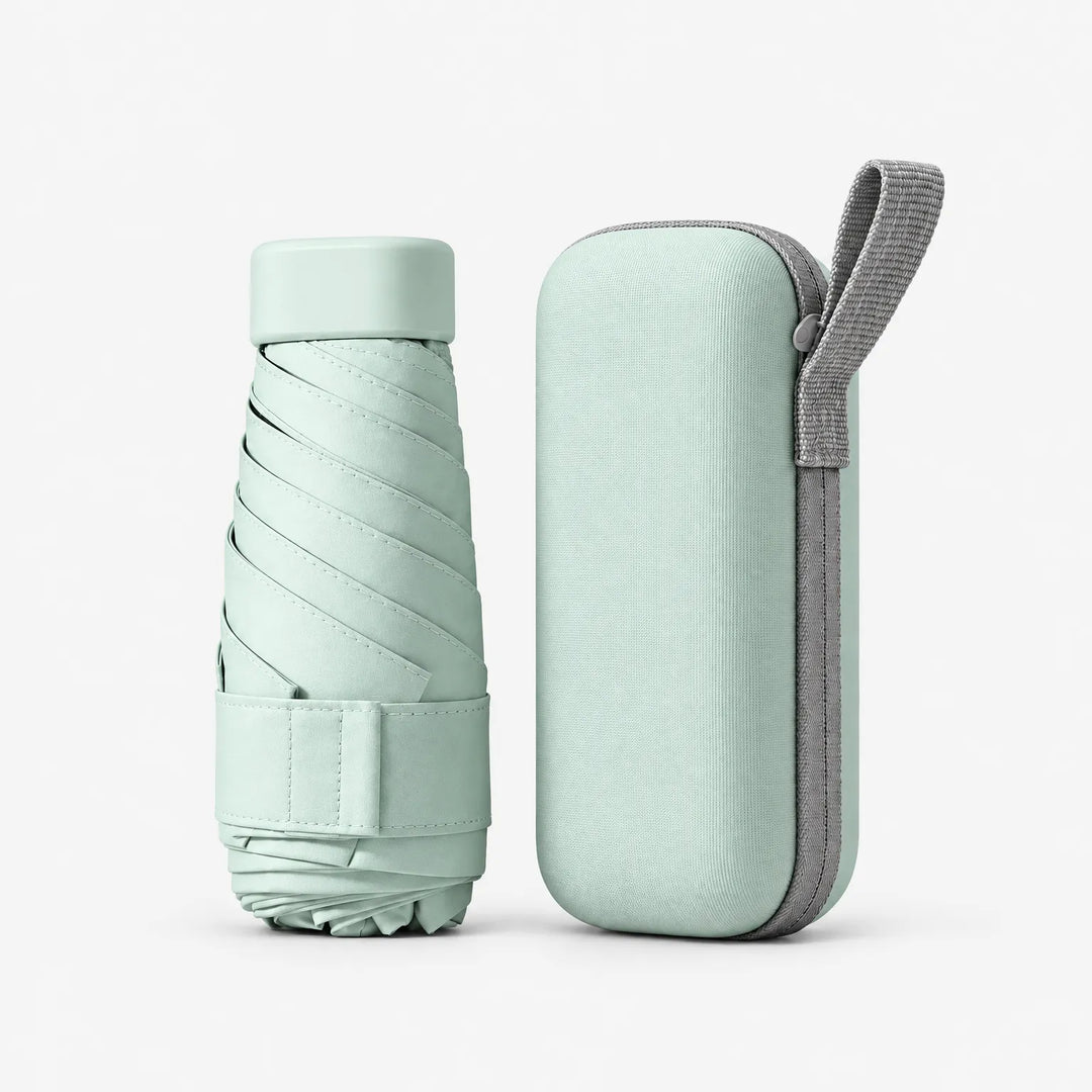 Mint green folded umbrella with its cap and strap beside a matching zippered hard case with a grey wrist loop, on white. 2