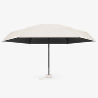 Open cream umbrella shown from the side against white, with a black underside, black shaft and a small cream cord loop at the handle. 4