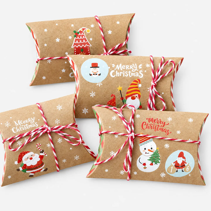 Four kraft pillow boxes with red and white twine, each printed with a different festive design such as Santa, a snowman and a gnome. 2