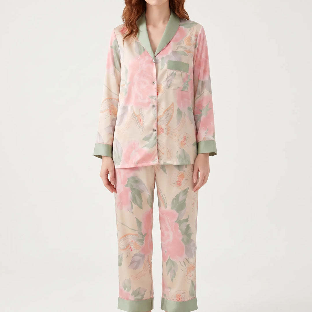Front view of a model in the pink floral pyjama set with green shawl collar, buttons, chest pocket and cuffs. 2