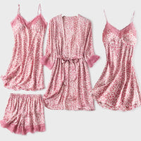 Flat lay of the four pink leopard-print satin pieces: lace-trimmed shorts, belted robe, camisole and slip nightdress. 4