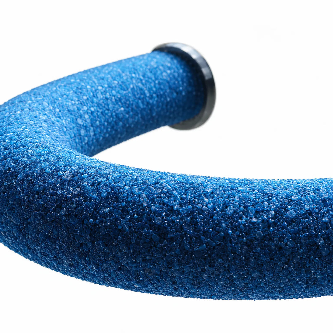 Close-up of the blue sand-coated surface of the curved perch, showing its coarse grit and a dark end washer. 4