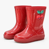 Pair of red glitter rain boots at an angle, with a cherry charm on the shaft and water droplets on the surface. 9