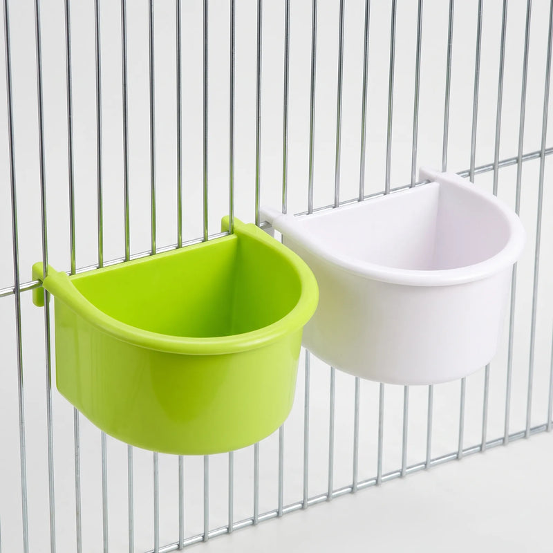 One green and one white half-round bowl hooked onto cage bars, shown at an angle to reveal their depth. 6