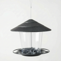 Dark charcoal version hanging empty, viewed slightly from above to show the feeding tray and seed openings inside the clear container. 5