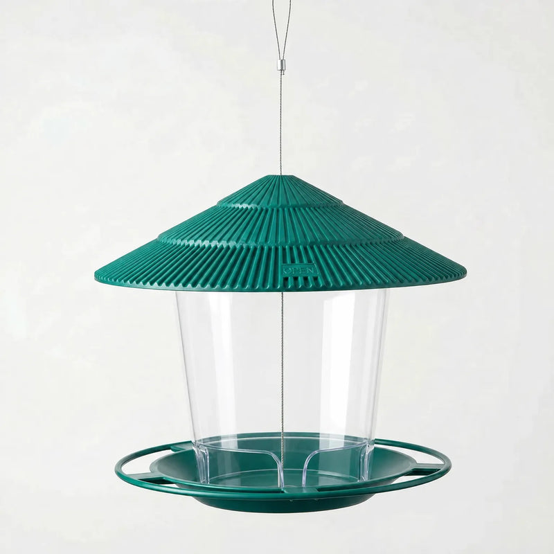 Dark green version hanging empty on a steel wire, with ribbed tiered roof, clear seed container and ring-edged feeding tray. 6