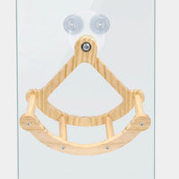 Front view of a wooden bird swing with a curved perch and dowel rungs, held to a glass pane by two suction cups. 1