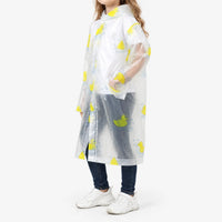 Side view of a girl in the clear raincoat with yellow rubber duck print, showing the hood, snap closure and a hand in the pocket. 5