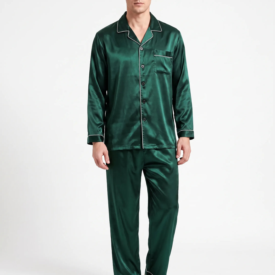 Front view of a model wearing the pyjama set in dark green satin with white piping and black buttons. 7