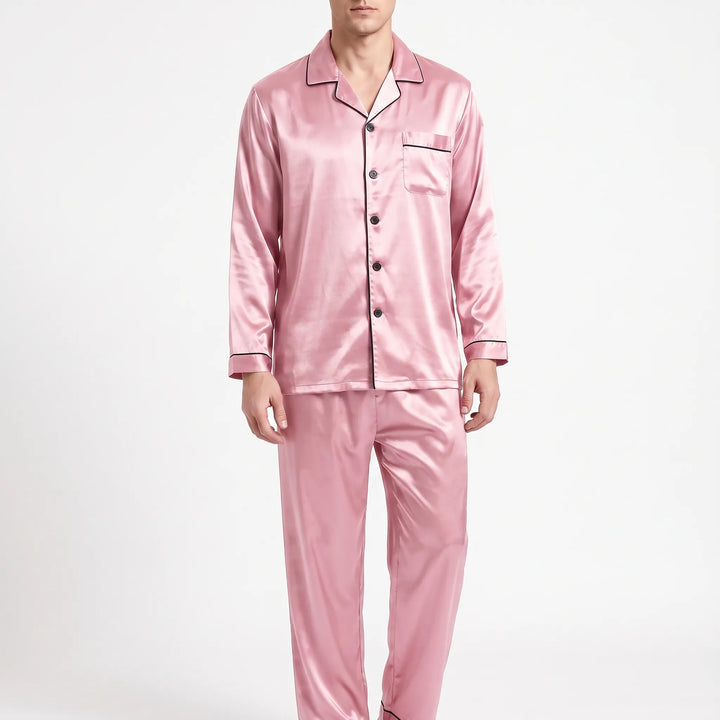 Front view of a model wearing the pyjama set in pink satin with dark piping and dark buttons. 9
