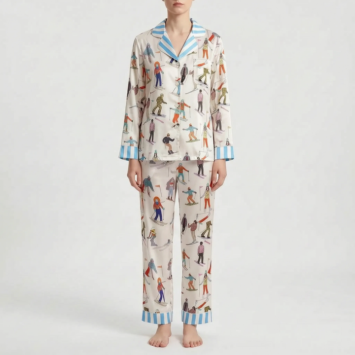 Front view of the cream skier-print pyjama set on a model against a plain backdrop, with blue striped collar and cuffs. 11
