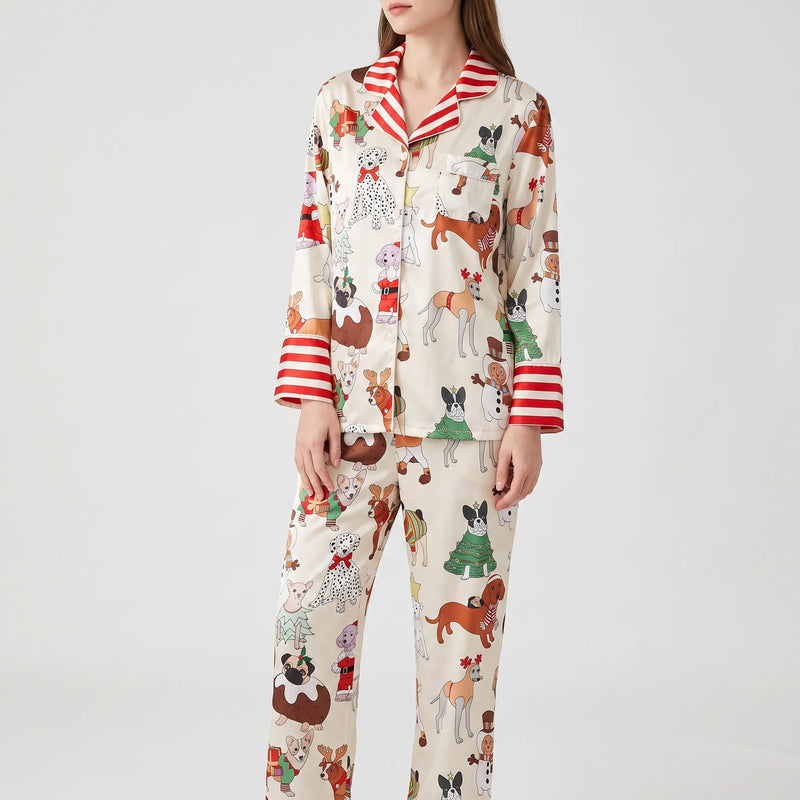 Model wearing a cream pyjama print option with dogs in festive costumes, finished with red and white striped collar and cuffs. 12