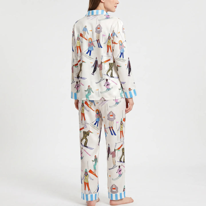 Back view of the model wearing the skier-print pyjama set, with blue striped cuffs and trouser hems visible. 3