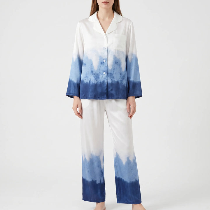 Front view of a model against a plain backdrop wearing the white pyjama top with chest pocket and blue ombre fading to navy. 2