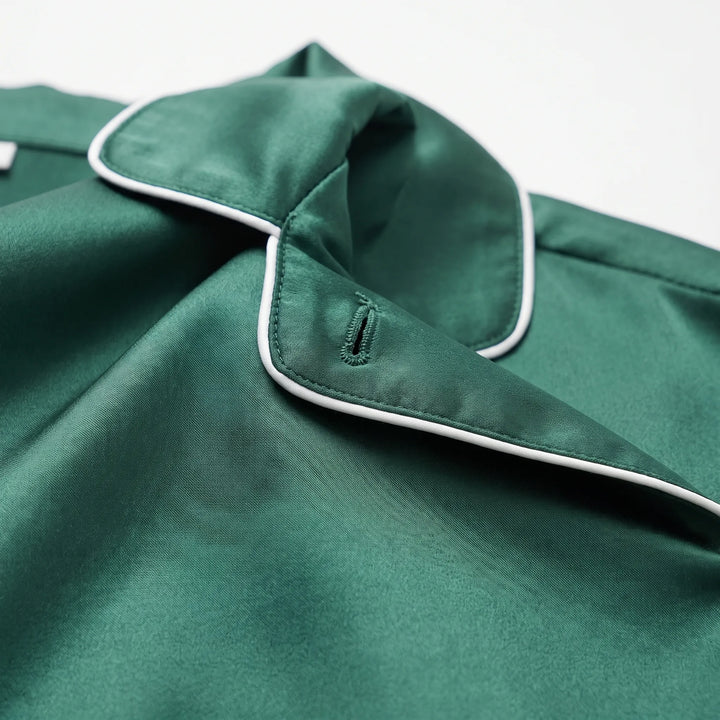 Close-up of the green satin collar with white piping and a stitched buttonhole, showing the smooth sheen of the fabric. 5