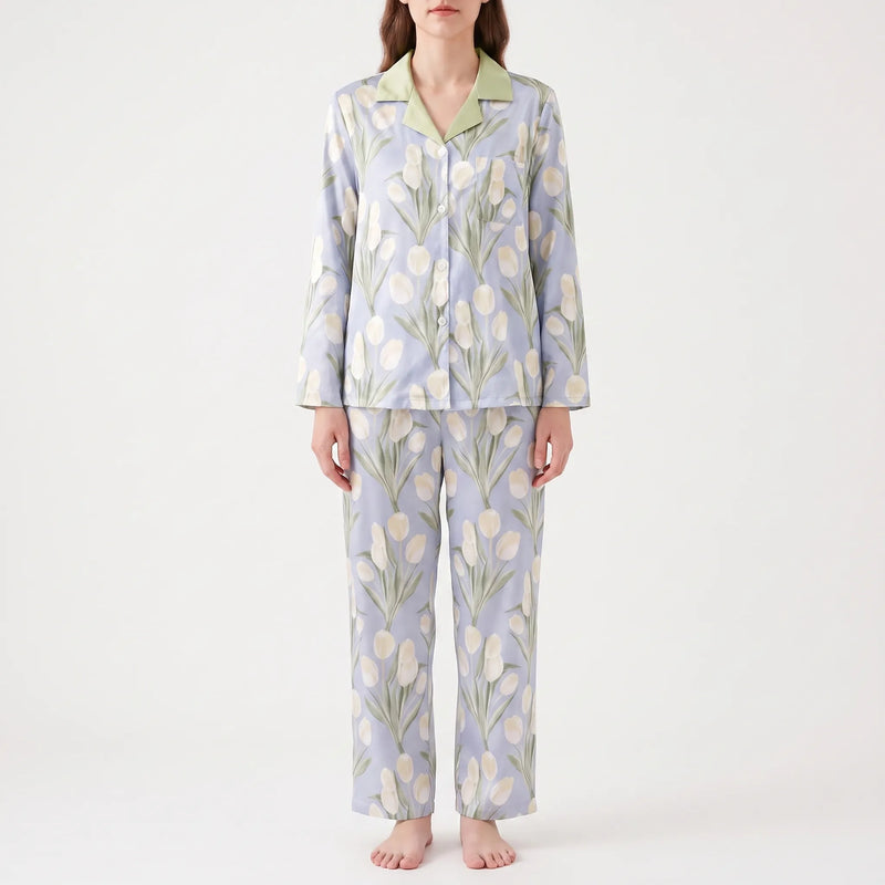 Front view of a model standing in the blue pyjama set with cream tulip print, green collar and wide straight trousers. 8