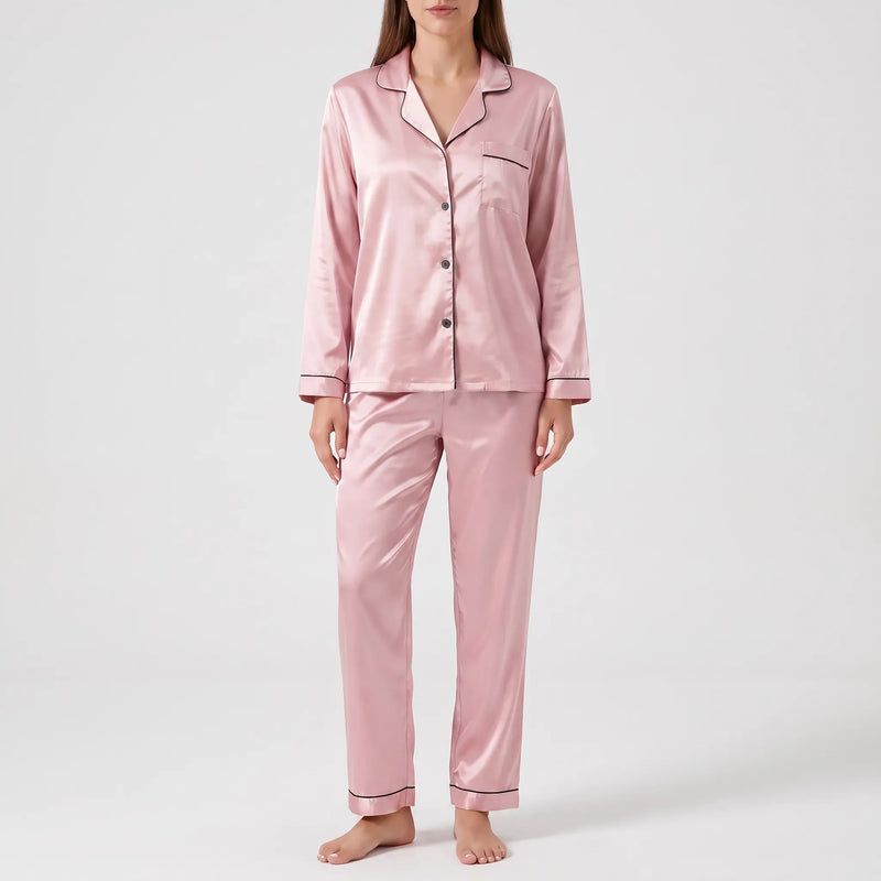 Model wearing the satin pyjama set in dusty pink with black piping and dark buttons, front view. 7