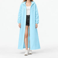 Studio front view of the light blue hooded raincoat worn open, with elastic cuffs and white drawstrings over a white top. 10