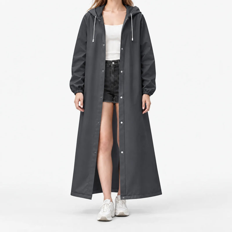 Studio front view of the dark grey hooded raincoat worn open with silver snap buttons and white drawstrings over black shorts. 11