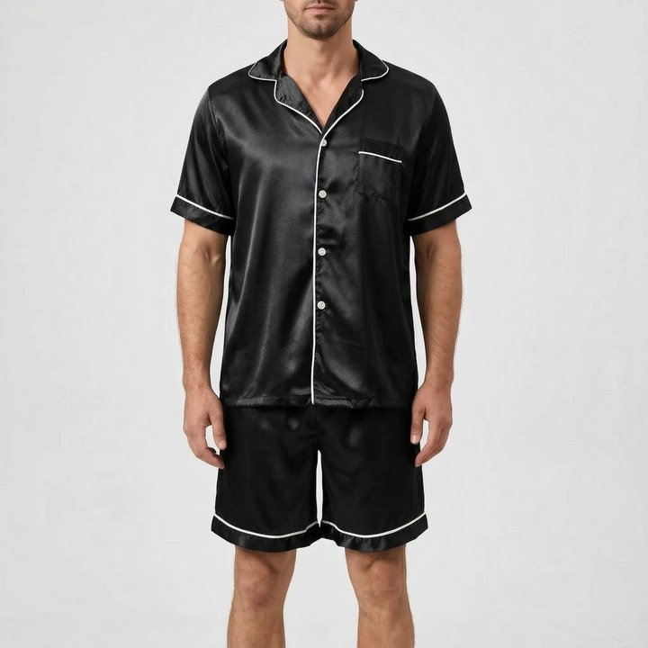 Model wearing the pyjama set in black satin with white piping and light buttons, front view. 9