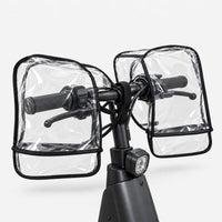 Rear view of clear transparent muffs covering both grips and brake levers of a black scooter handlebar, shown on a white background. 4