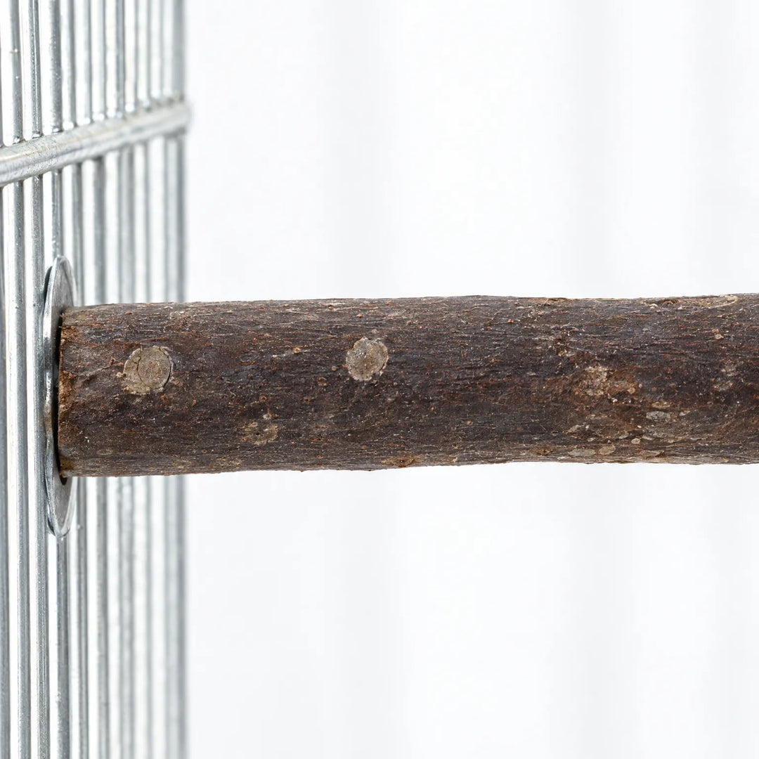 Close-up of a bark-covered wooden perch fixed to a metal cage wire panel with a round washer, showing knots and grain. 3
