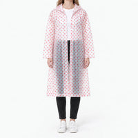Front view of the translucent raincoat with red polka dots, snap buttons visible, worn over a white tee and black jeans. 10