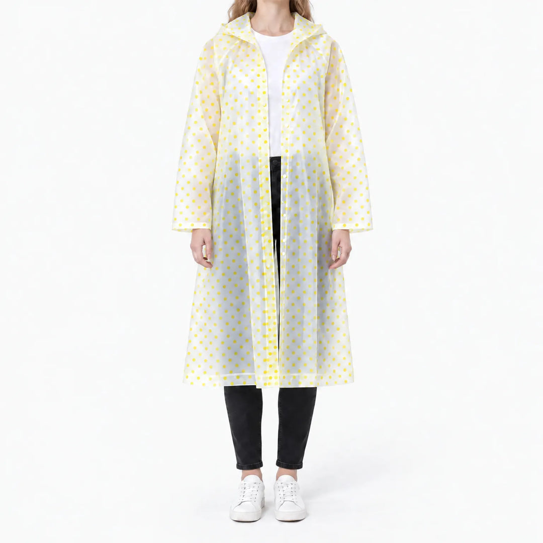 Front view of the translucent raincoat with yellow polka dots, worn open over a white tee and black jeans. 11