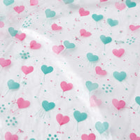 Close-up of the clear plastic material printed with pink and teal hearts and small dots. 6