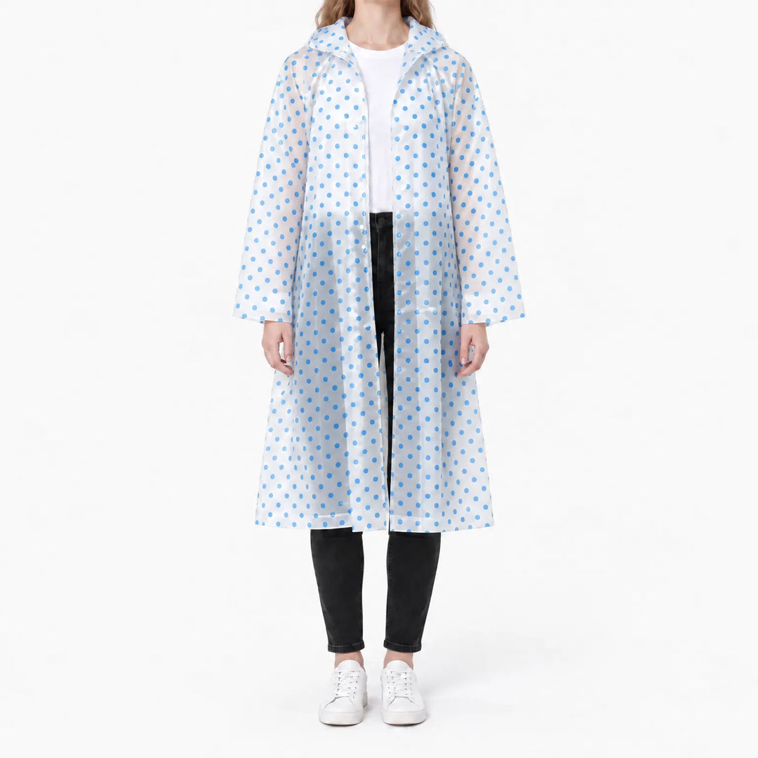 Front view of the translucent raincoat with blue polka dots, worn open over a white tee and black jeans. 9