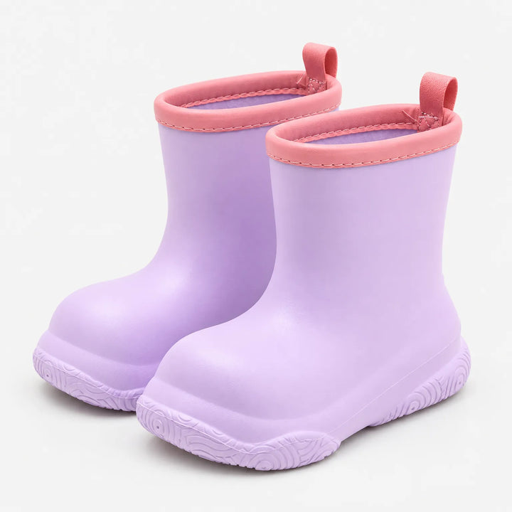 Pair of lilac pull-on wellies with coral pink collars and pull loops, shown at an angle on a plain white background. 4