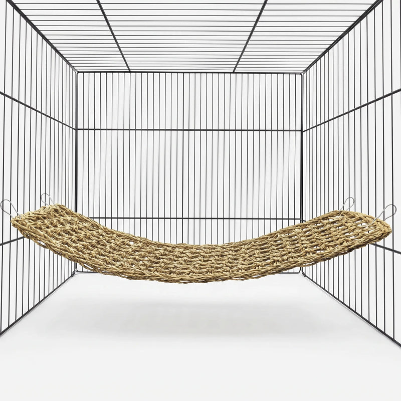 Woven natural-fibre hammock hung by four metal clips inside an empty wire cage, shown against a plain white background. 1