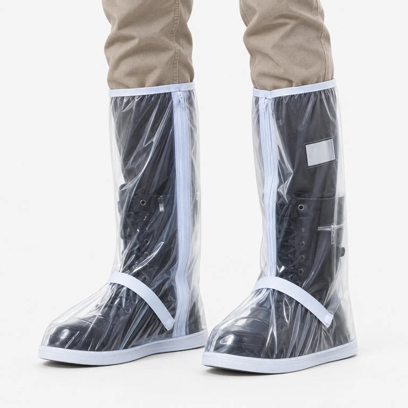 Clear transparent shoe covers with white trim and zipper worn over black lace-up boots, shown front view on a white background. 2