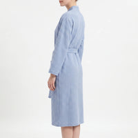 Side view of the blue waffle robe on a model, showing the long sleeve, belt and knee-length hem. 4