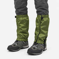 Olive green ripstop gaiters with elastic cuffs and under-boot strap, worn over grey hiking shoes against a plain white background. 2