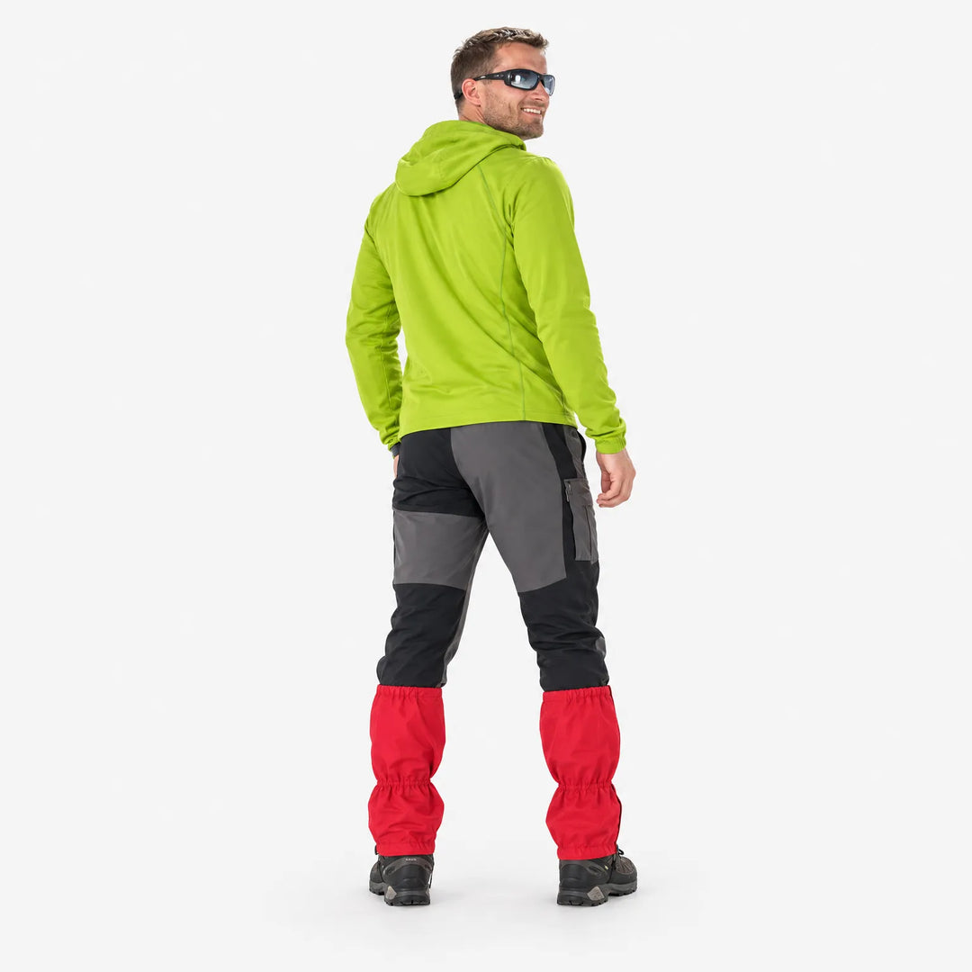 Rear view of a smiling man in sunglasses and a lime green hoodie, showing the back of red gaiters worn over boots. 4