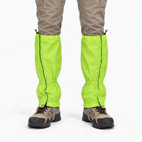 Front view of bright lime green gaiters worn over hiking boots with khaki cargo trousers, showing side zips and snap fasteners. 7