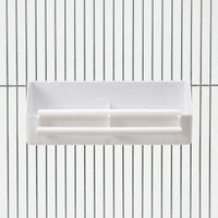 Front view of a white plastic two-compartment feeder with two perches, hung on the vertical bars of a metal cage. 1